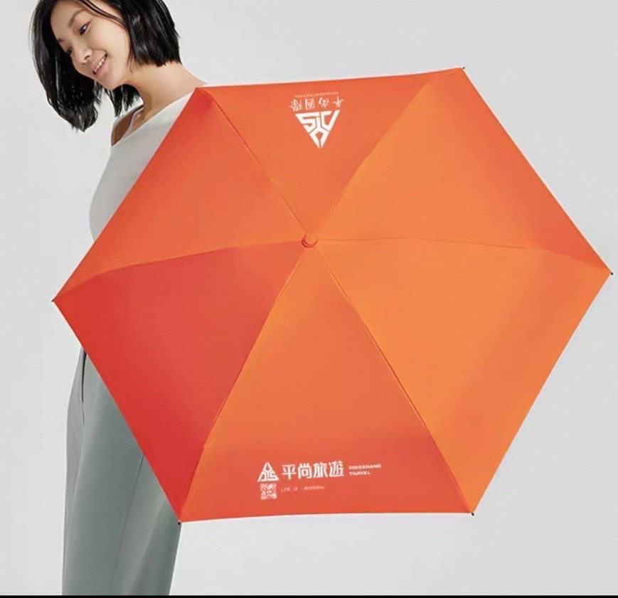 印有平尚標誌的橘色紀念雨傘展示照
